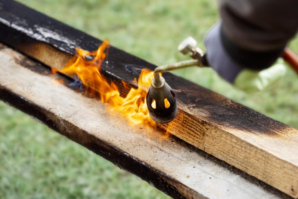 Person burning wood part of the shou sugi ban process