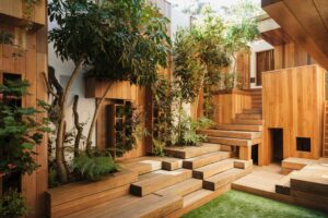 Atrium with wooden stairs and walls, along with grass and trees